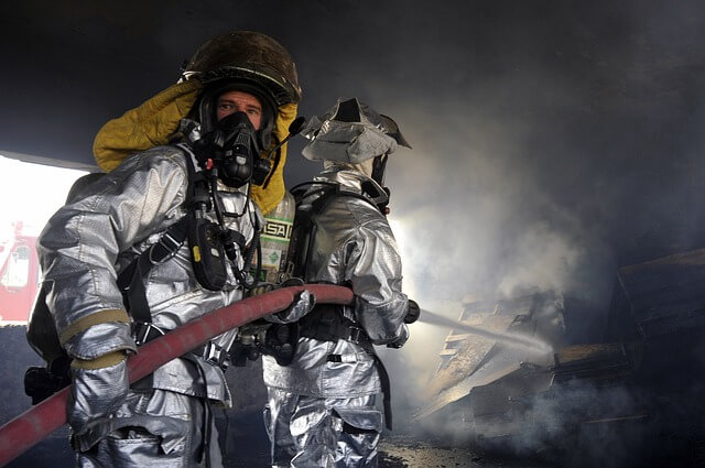 Zwei Feuerwehrmänner löschen einen Brand