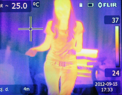 Wärmebildkamera zeigt die Körperwärme einer Frau in orangener Farbe